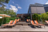 Terrasse mit orangefarbenen Sonnenliegen im Freien.