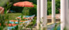 Gartenwiese am Schwimmbecken mit Liegestühlen und Sonnenschirmen.