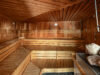 Sauna mit Holzbänken und Aufgusssteinen.